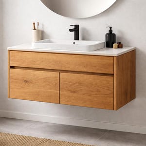 May include: A modern bathroom vanity with a light wood finish. It features a white countertop, a rectangular sink, and a black faucet. The vanity has two drawers and is mounted on the wall. A round mirror hangs above the sink.