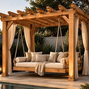 May include: A wooden swing bed with a pergola-style frame. The bed has a cream-colored mattress and is adorned with pillows and a blanket. Sheer white curtains hang from the frame, and the structure is supported by thick wooden posts. The scene is outdoors.
