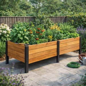 May include: A raised wooden garden bed filled with various plants, including tomato plants with red tomatoes. The bed has a natural wood finish and black metal legs. A green garden hose and watering can are nearby.