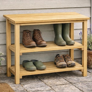 May include: A wooden shoe rack with three shelves, holding various footwear. The rack is made of light-colored wood and is placed outdoors. Boots, shoes, and clogs are arranged on the shelves. A potted plant is on the right side.