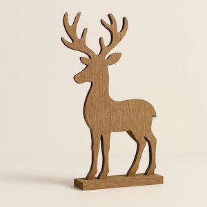 Peut inclure: Une figurine de cerf en bois avec des bois détaillés et une base rectangulaire. Le cerf est de couleur marron clair et se tient debout, mettant en valeur une texture de grain de bois naturel. Décoration pour les fêtes ou la maison rustique.