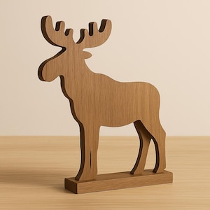 Könnte beinhalten: Eine Holz-Elchfigur mit natürlicher Holzmaserung. Der Elch steht auf einem rechteckigen Sockel. Das Geweih ist groß und detailliert. Die Figur ist ein dekoratives Objekt.