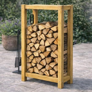 May include: A wooden log store filled with cut firewood. The rack is made of light-coloured wood and has a rectangular shape. A set of black fireplace tools stands nearby. The background features greenery and a stone patio.