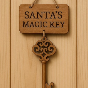 Pode incluir: Placa de madeira clara com o texto "SANTA'S MAGIC KEY" e uma chave decorativa pendurada abaixo. A placa e a chave são de cor castanho claro e estão sobre um fundo de madeira clara.