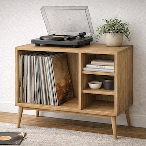 Könnte beinhalten: Ein hölzerner Plattenspieler-Ständer mit einem schwarzen Plattenspieler oben. Der Ständer hat offene Regale mit Schallplatten, Büchern und dekorativen Gegenständen. Oben steht eine kleine Topfpflanze. Der Ständer ist aus hellem Holz gefertigt.