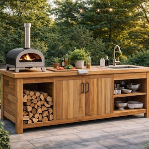 Może przedstawiać: Drewniana wyspa kuchenna na zewnątrz z piecem do pizzy, zlewem i schowkiem. Wyspa posiada piec do pizzy ze stali nierdzewnej z widocznym ogniem, zlew z kranem oraz miejsce do przechowywania drewna opałowego. Wyspa otoczona jest zielenią.