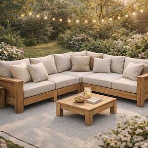 May include: An outdoor sectional sofa with light beige cushions and wooden frame. A matching square coffee table and side table are also visible. The setting is an outdoor patio with lush greenery and string lights.