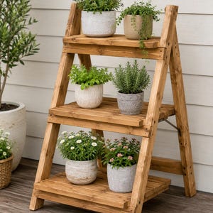 May include: A three-tiered wooden A-frame plant stand featuring a natural brown finish. The stand holds six potted plants in various textured ceramic and stone pots, arranged with two plants on each of the three horizontal slatted shelves.