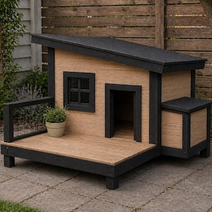 Può includere: Una moderna cuccia per cani con tetto e finiture nere e rivestimento marrone chiaro. Ha una piccola finestra, una porta e un piccolo portico. Una piccola pianta in vaso è sul portico. La cuccia è su un patio in pietra.