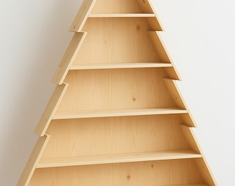 May include: A wooden bookshelf shaped like a Christmas tree. The natural wood-toned shelves are arranged in a triangular shape with multiple horizontal shelves. The bookshelf stands on a rectangular base and is against a white wall.