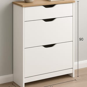 Könnte beinhalten: Ein weißer Schrank mit drei Schubladen und einer hellen Holzplatte. Der Schrank ist 90 cm hoch, 60 cm breit und 31,5 cm tief. Eine kleine Topfpflanze und Bücher stehen oben drauf.