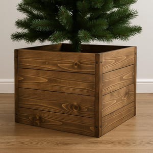 Pode incluir: Um suporte quadrado de madeira para árvore de Natal com acabamento castanho escuro. O suporte é construído com tábuas horizontais e apresenta grão de madeira visível. Uma árvore de Natal verde é colocada dentro do suporte.