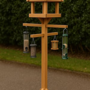 May include: A wooden bird feeder with a multi-level design. It has a peaked roof, a central post, and arms holding various bird feeders. The feeders include mesh and clear tube designs, filled with birdseed. The structure is made of light brown wood.