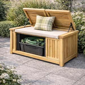 May include: A wooden outdoor storage bench with a hinged lid and a light-coloured cushion. The bench has a compartment for storing items, and a green plaid pillow rests on the cushion. A green garden hose is visible inside the storage area.