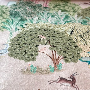 May include: A whimsical illustration of a forest scene with a large green tree, a monkey, birds, a peacock, and a deer. The background is a light beige color.