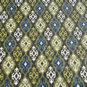 May include: A fabric with a repeating pattern of green, blue, and white diamond shapes. The diamonds have a stylized floral design inside.