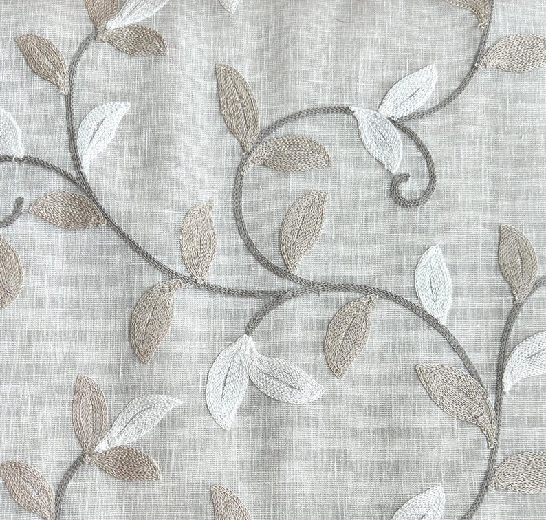 May include: Beige fabric with an embroidered design of brown and white leaves and vines.