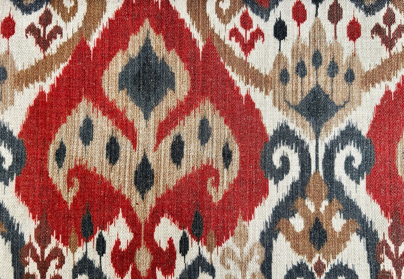 May include: Red, brown, black and white patterned fabric with an ikat design.