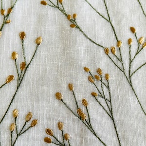May include: White fabric with an embroidered pattern of green stems and gold leaves.