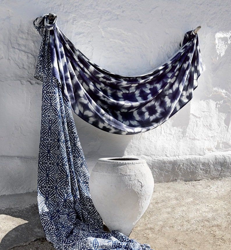May include: A white ceramic pot with a blue and white patterned fabric draped over it. The fabric has a tie-dye pattern and a geometric pattern.