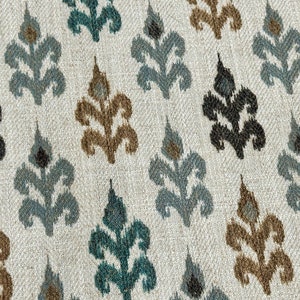 May include: A white fabric with a repeating pattern of brown, teal, and black stylized floral designs.