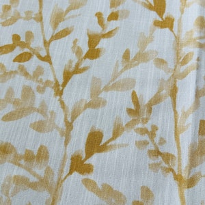 May include: White fabric with a subtle texture featuring a repeating pattern of gold leaf branches and leaves.