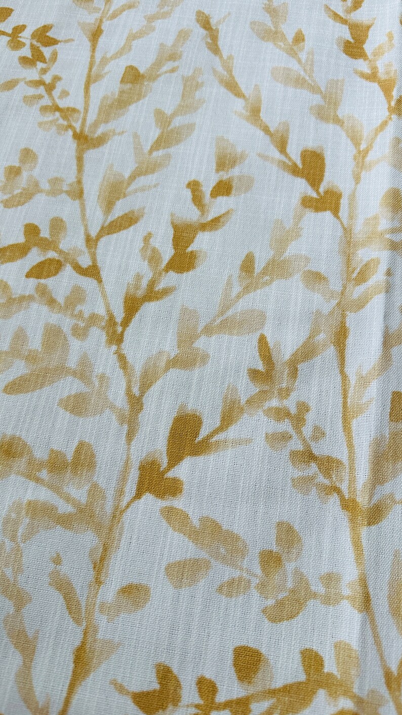 May include: White fabric with a subtle texture featuring a repeating pattern of gold leaf branches and leaves.