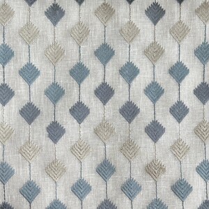 Puede incluir: Primer plano de una tela con un patr&oacute;n repetitivo de rombos azules y beige. La tela tiene una textura sutil y un fondo gris claro.