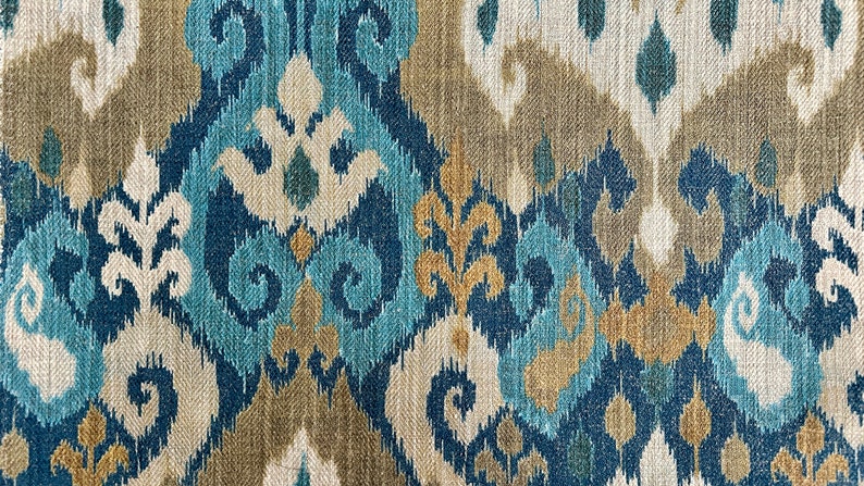 May include: Blue, beige, and gold patterned fabric with an ikat design.