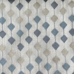 Puede incluir: Una tela blanca con un patr&oacute;n repetitivo de rombos azules y marrones. La tela tiene una textura de lino sutil.