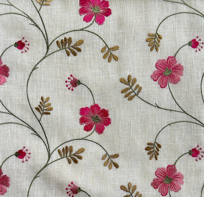 May include: A white fabric with embroidered pink flowers and brown stems. The fabric has a subtle linen texture.