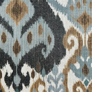Puede incluir: Primer plano de una tela con un patr&oacute;n ikat azul, marr&oacute;n y blanco. La tela tiene una textura tejida y un brillo sutil.