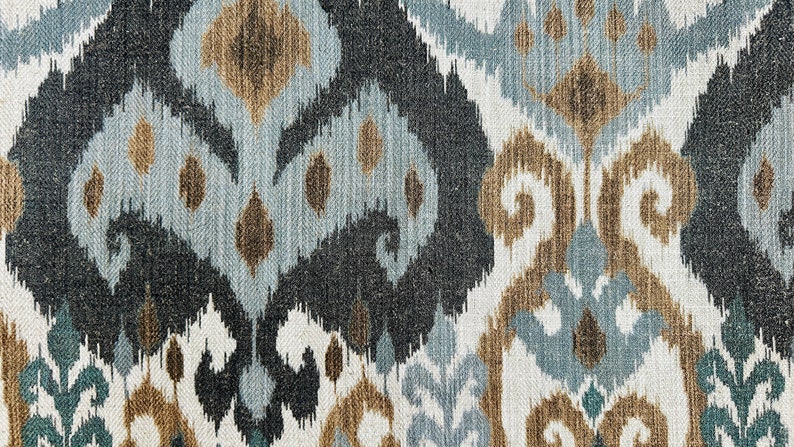 Puede incluir: Primer plano de una tela con un patr&oacute;n ikat azul, marr&oacute;n y blanco. La tela tiene una textura tejida y un brillo sutil.