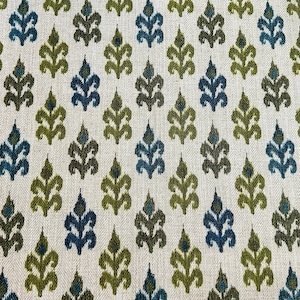 May include: A white fabric with a repeating pattern of green and blue stylized floral shapes.