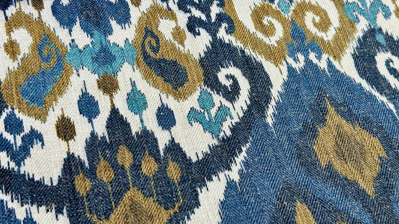 May include: Blue, brown, and white ikat fabric with a repeating pattern of swirls and diamonds.