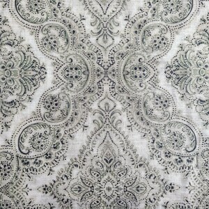 May include: A white fabric with a black and green paisley pattern.