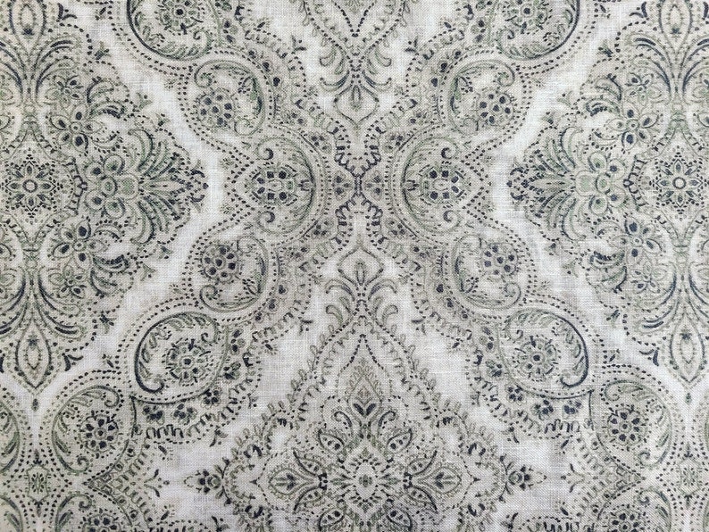 May include: A white fabric with a black and green paisley pattern.