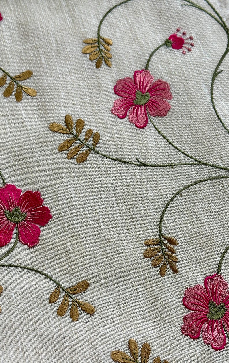 May include: White fabric with embroidered pink flowers and brown leaves. The fabric has a subtle texture.