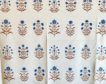 May include: White fabric with a repeating pattern of blue and brown floral designs. The fabric has a subtle texture.