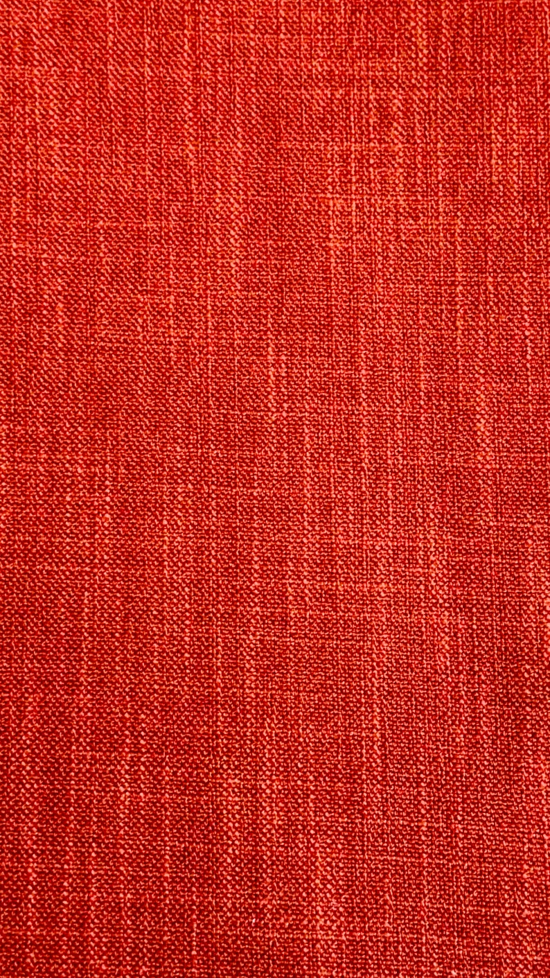 May include: Close-up of a red textured fabric with a woven pattern.