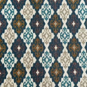 May include: A fabric with a repeating geometric pattern in shades of blue, brown, and beige. The pattern features a diamond shape with a stylized floral design inside.