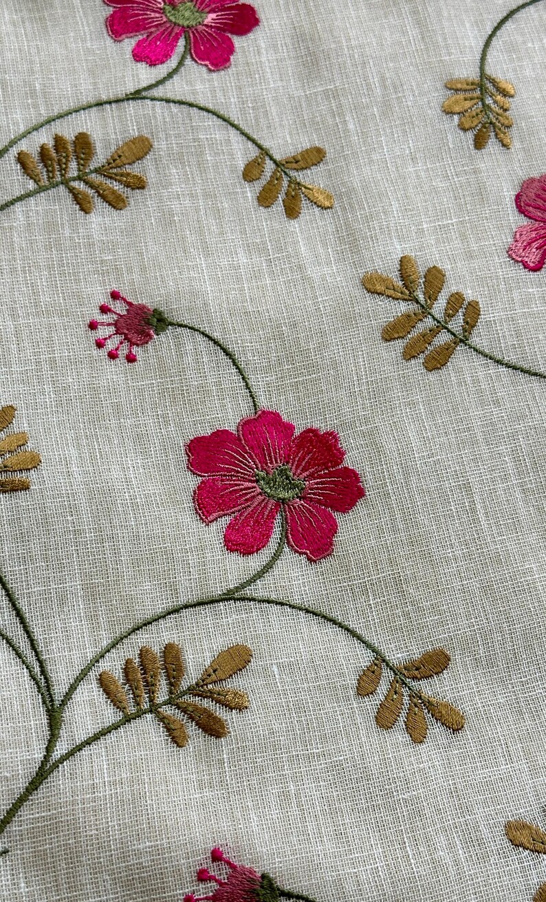 May include: White fabric with embroidered pink flowers and gold leaves. The fabric has a subtle texture.