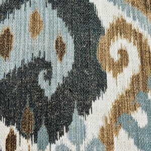 Puede incluir: Primer plano de una tela con un patr&oacute;n ikat marr&oacute;n, azul y blanco. La tela tiene una superficie texturizada y un patr&oacute;n repetitivo de remolinos y puntos.