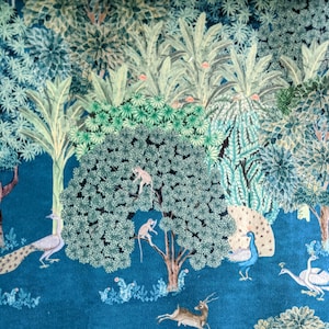 May include: A teal blue background with a stylized illustration of a jungle scene. The scene includes a peacock, monkeys, and a deer. The illustration is done in shades of green, brown, and white.