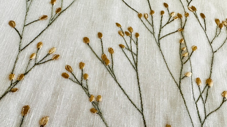 May include: White fabric with a delicate embroidered design of green stems and gold leaves.