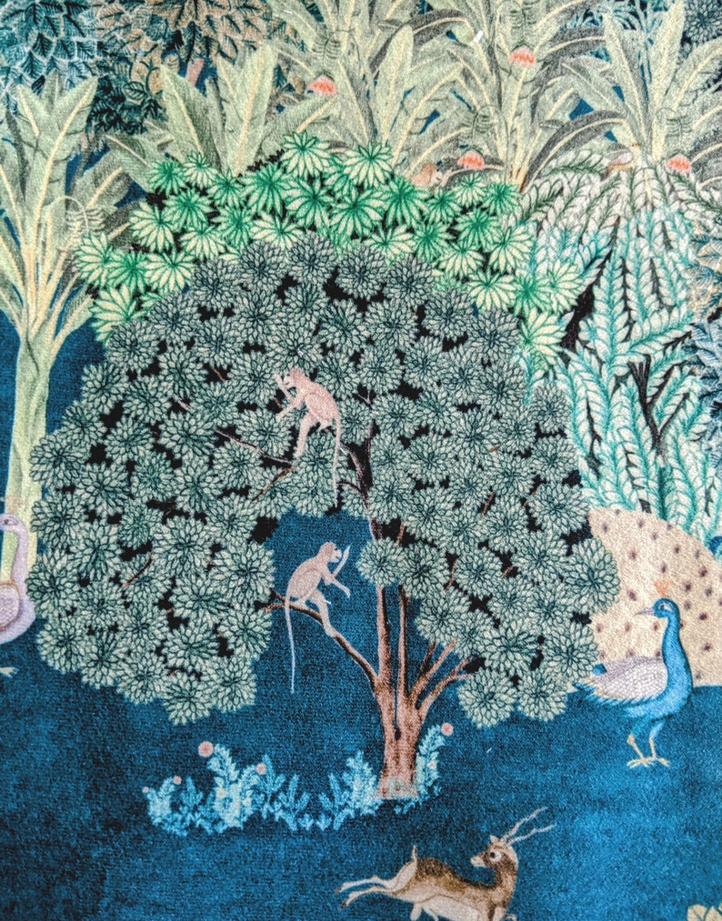 May include: A blue and green patterned fabric with a large tree in the center. The tree has two monkeys climbing on it. There is a peacock on the right side of the image and a deer on the bottom.