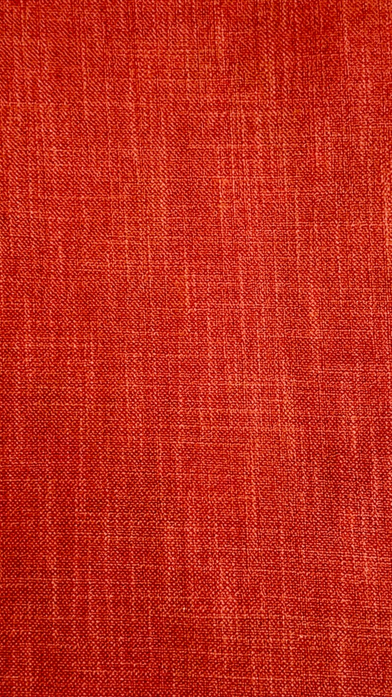 May include: A close-up of a red textured fabric with a woven pattern.