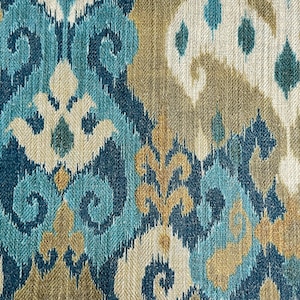 May include: Blue, beige, and white patterned fabric with an ikat design. The fabric has a woven texture.
