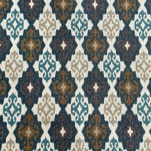 May include: A close-up of a fabric with a repeating geometric pattern. The pattern is made up of diamonds with a brown, teal, and white design. The fabric has a textured surface.