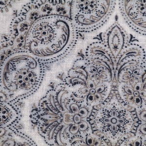 May include: A white fabric with a paisley pattern in shades of brown and black. The fabric has a subtle texture and a delicate design.